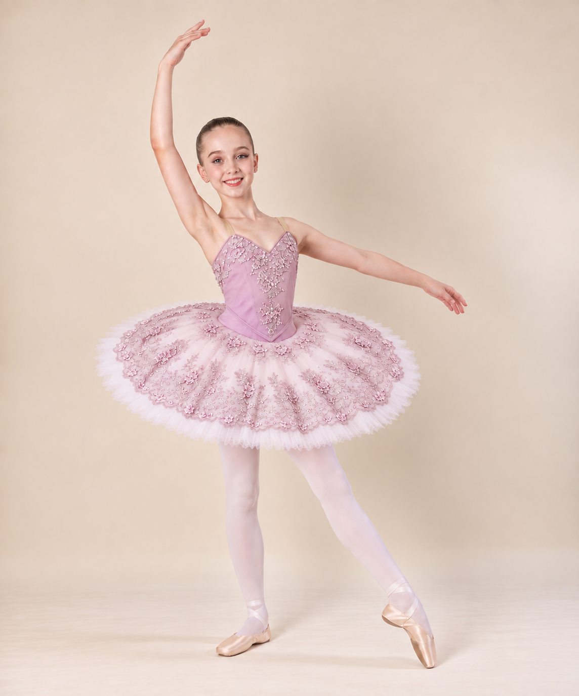 Dancer wearing a blush pink classical tutu with delicate floral embellishment